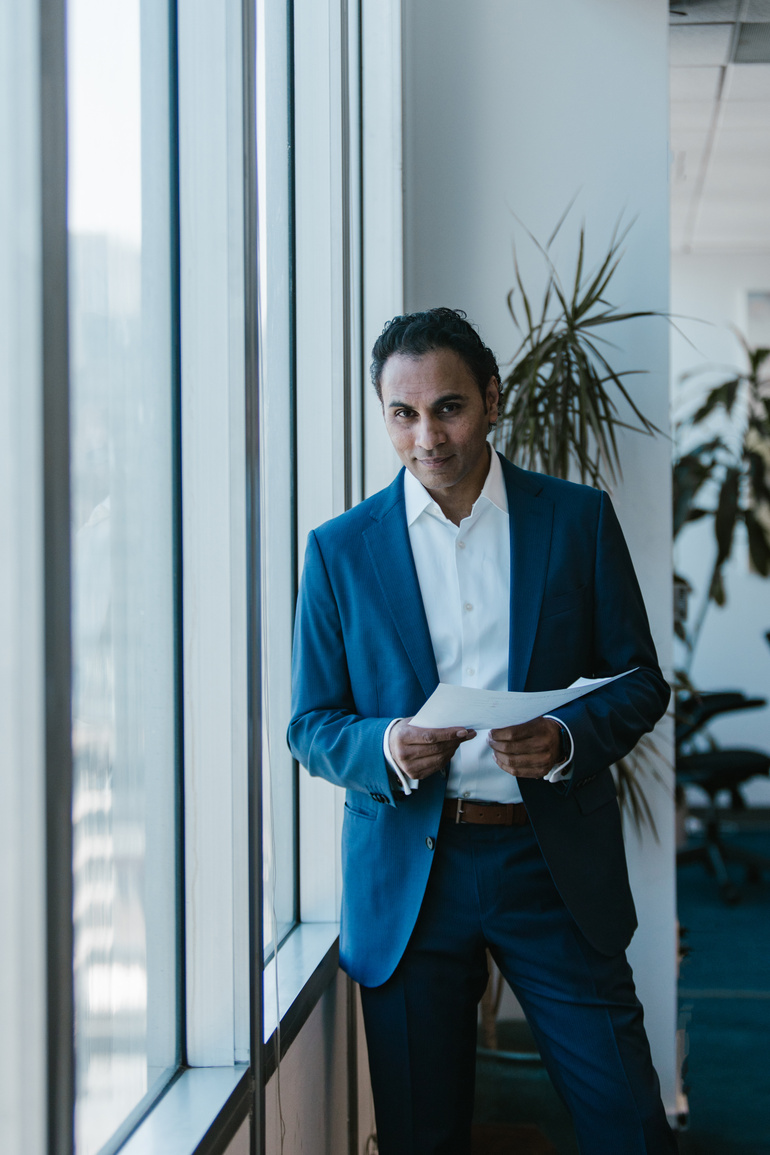 Man in Blue Suit Standing by the Window